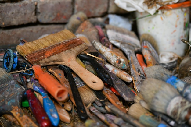 De nombreux pinceaux sales de l'artiste dans l'atelier