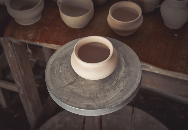 De nombreux pots en argile sont sur la table en poterie