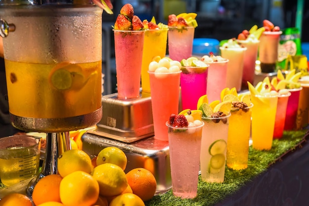 De nombreux smoothies et boissons dans des gobelets en plastique dans la cuisine de rue de Jalan Alor sur le marché de Kuala Lumpur