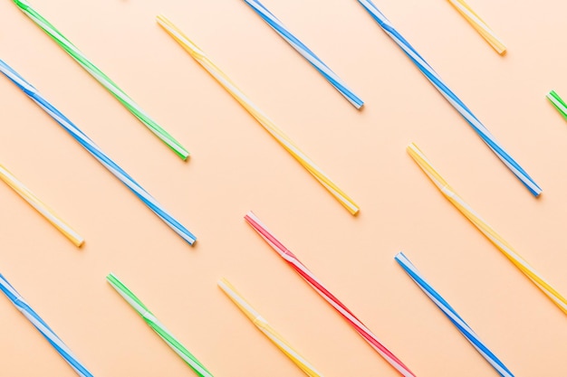 De nombreux tubes en plastique multicolores pour cocktail sur la vue de dessus de fond coloré