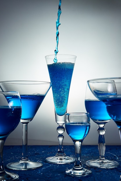 Nombreux verres à champagne bleu ou cocktail.