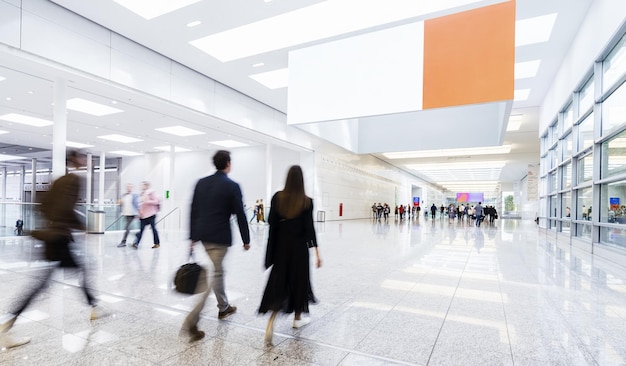 De nombreux visiteurs du salon courent sous une affiche publicitaire