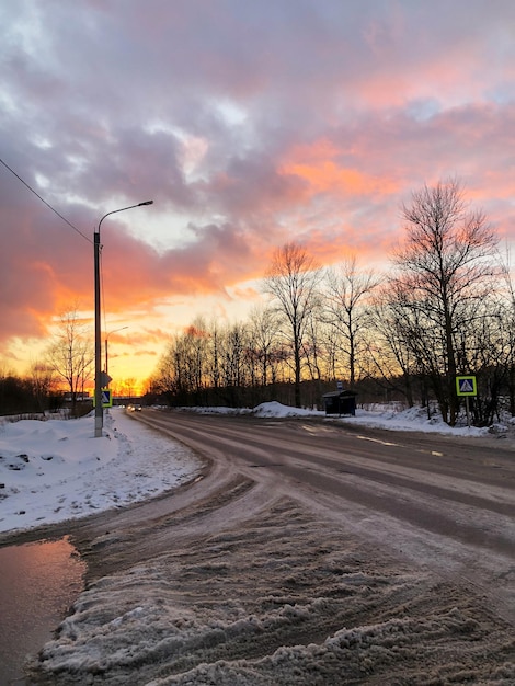 Non nettoyé de la neige et de la route de terre au coucher du soleil