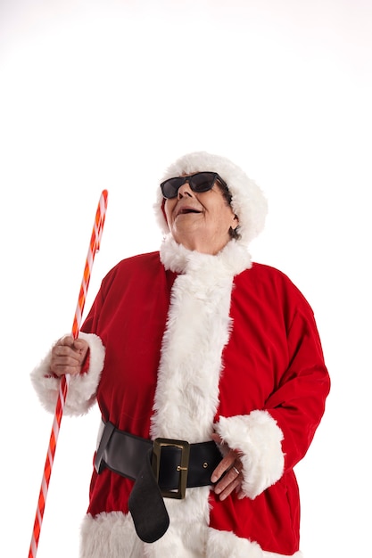 Un nonagénaire en costume de Père Noël avec un fond blanc en levant.