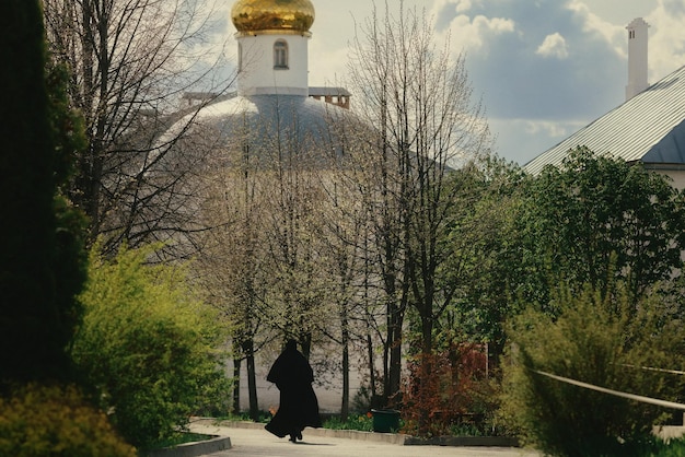 Une nonne en vêtements noirs se promène dans la cour d'un monastère orthodoxe russe