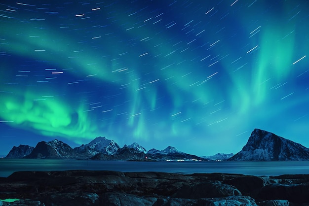 Northern Lights, Aurora Borealis vert brillant dans le ciel étoilé de la nuit avec des traces d'étoiles en hiver îles Lofoten, Norvège