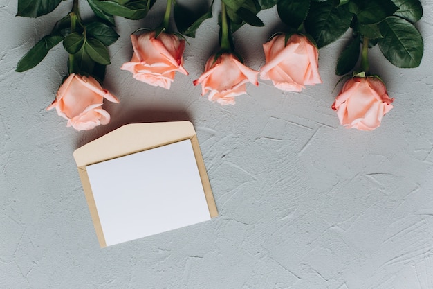 Note de papier blanc avec enveloppe, cadeaux et rose rose