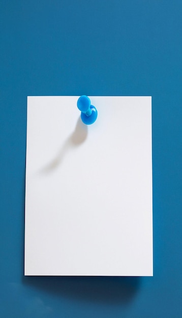 Photo note de papier vierge blanche épinglée sur fond bleu générarive ai