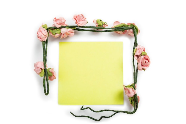 Notes jaunes vides avec un cadre de tige de fleurs rose rose