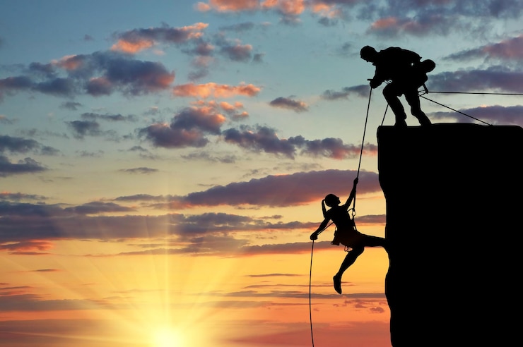 Photo notion d'aide. silhouette de deux grimpeurs s'entraident