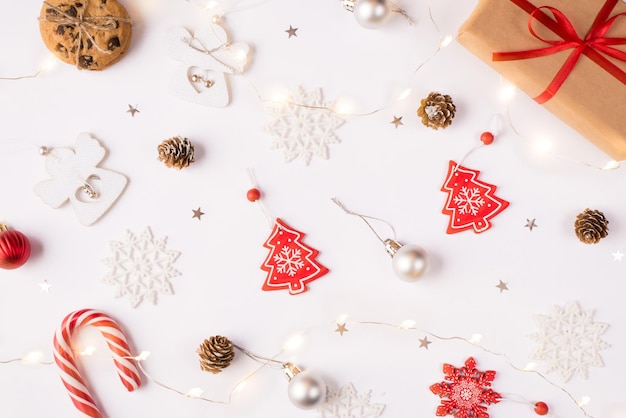 Notion de composition de Noël. Gros plan au-dessus de la photo de la boîte-cadeau des boules de paillettes de nourriture de guirlande de bokeh de flocons de neige sur un bureau blanc