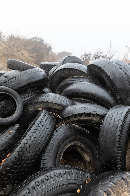 Notion écologique. Tas de vieux pneus. Décharge de vieux pneus usagés dans la ville un jour d'automne brumeux