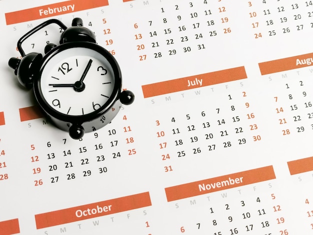 Notion de gestion du temps. Réveil sur calendrier.