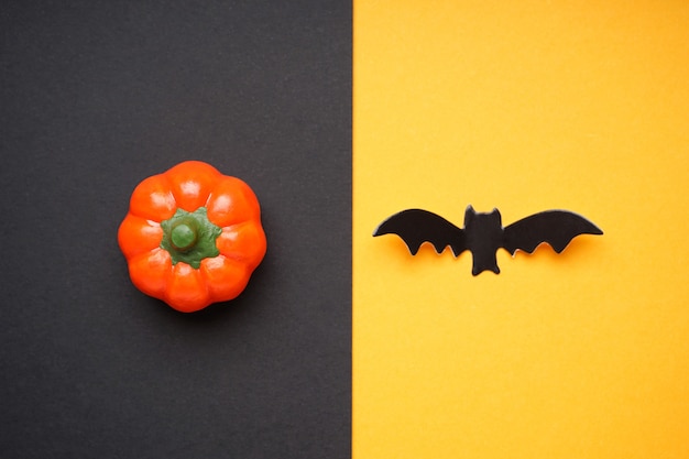 Notion D'halloween. Citrouille D'halloween Et Chauve-souris Sur Fond Noir-jaune, Mise à Plat.