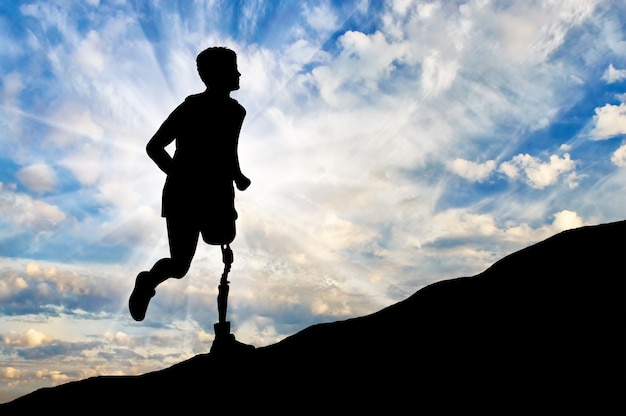 Notion de handicap. Homme avec une jambe prothétique qui monte la colline