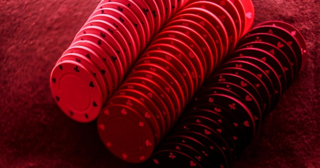 Notion de jeu de poker. Notion de casino. Pile de jetons de poker au feu rouge sur la table de poker.