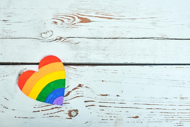 Notion LGBT. Les couleurs d'arc-en-ciel de coeurs se trouvent sur le fond en bois