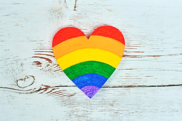 Notion LGBT. Les couleurs d'arc-en-ciel de coeurs se trouvent sur le fond en bois