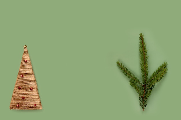 Notion de Noël et du nouvel an. Branche de sapin et arbre de Noël fait maison sur fond vert, place pour votre texte