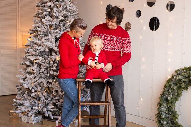 Notion de Noël. Nouvelle année. Garçon et ses parents près d'un arbre de Noël