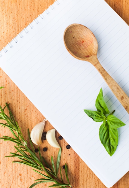 Notion de recette. Feuille de papier vierge sur une planche de bois avec des épices