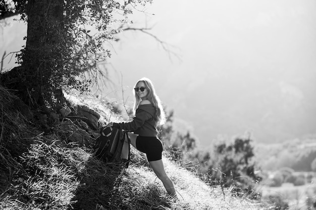 Notion de tourisme. Randonneur femme avec sac à dos sur les collines. Fille de tourisme en randonnée dans les montagnes avec des outils de randonnée. Mode de vie actif.