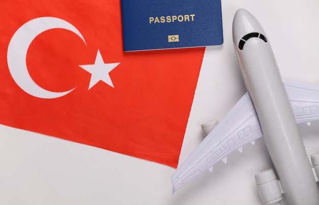 Notion de voyage. Avion de passagers, passeport et drapeau turc sur fond blanc