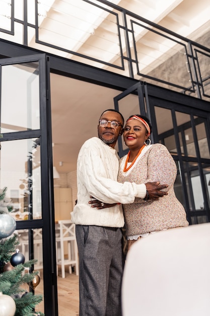 Notre Noël. Faible angle d'un joli couple heureux en regardant leur arbre de Noël