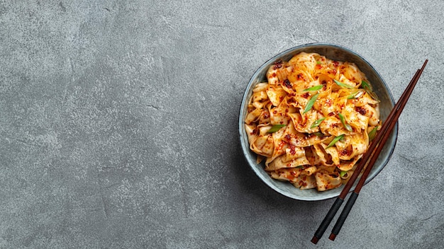 Photo noudles à l'ail et à l'huile de piment sur un fond en béton cuisine chinoise vue supérieure espace de copie