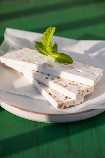 Nougat blanc tranché aux amandes sur table en bois