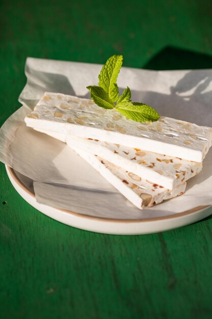 Nougat blanc tranché aux amandes sur table en bois