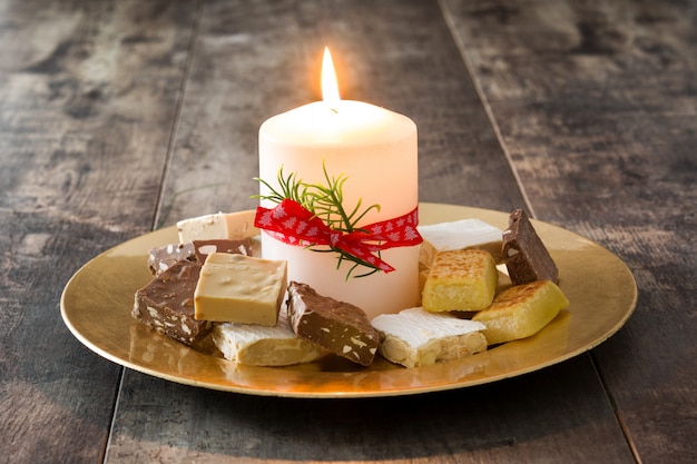 Photo nougat de noël et bougie blanche sur table en bois