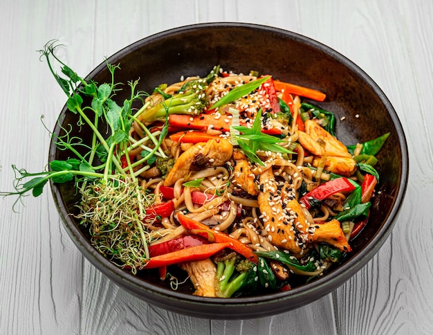 Nouilles asiatiques de plat avec le poulet et les légumes