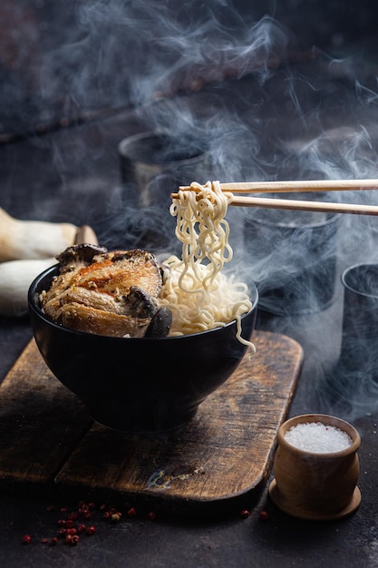 Nouilles aux champignons eringi dans une assiette noire