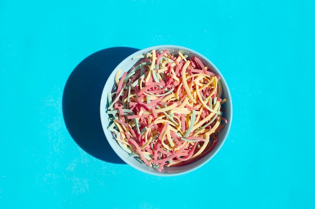 Nouilles Aux Légumes Colorés Un Gros Plan De Pâtes Colorées Saupoudrées De Farine Sur Fond Bleu Un Endroit Pour Copier