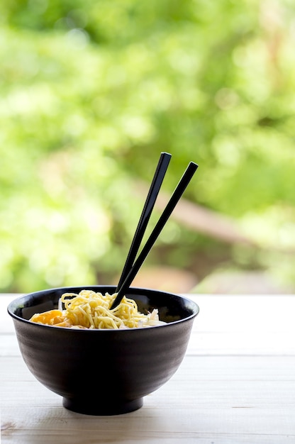 Photo nouilles aux oeufs chinois et porc sur la table en bois