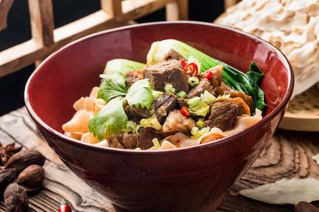 Nouilles de boeuf soupe rouge épicée dans un bol sur la table en bois