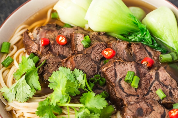 Nouilles de boeuf soupe rouge épicée dans un bol sur la table en bois