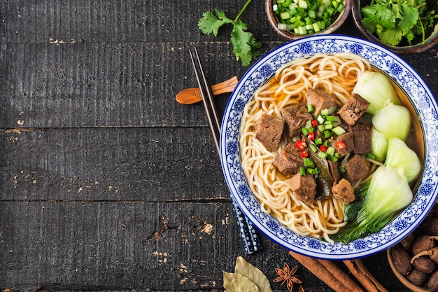 Nouilles de boeuf soupe rouge épicée dans un bol sur la table en bois