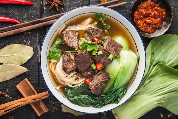 Nouilles De Boeuf Soupe Rouge épicée Dans Un Bol Sur La Table En Bois