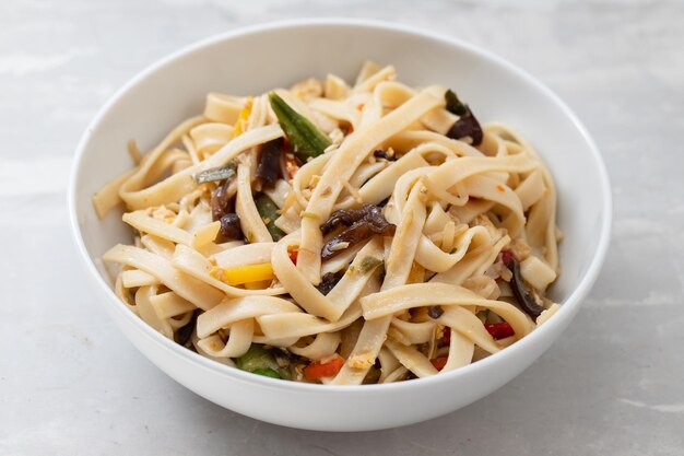 Nouilles bouillies Udon avec légumes sur bol en céramique