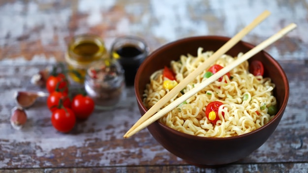 Nouilles chinoises dans un bol. Bâtonnets de nourriture. Manger des nouilles chinoises. Mise au point sélective.