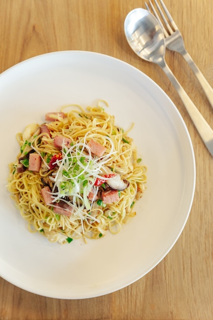 Nouilles chinoises sautées au jambon et viande de crabe sur fond de table en bois