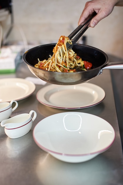 Nouilles claires de riz de restauration rapide asiatique cuisinant avec de la viande frite et des légumes épicés