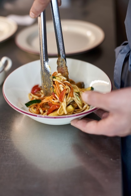 Nouilles claires de riz de restauration rapide asiatique cuisinant avec de la viande frite et des légumes épicés