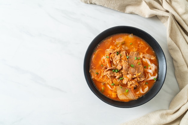 Nouilles coréennes de ramen d'udon avec du porc dans la soupe de kimchi - style de cuisine asiatique