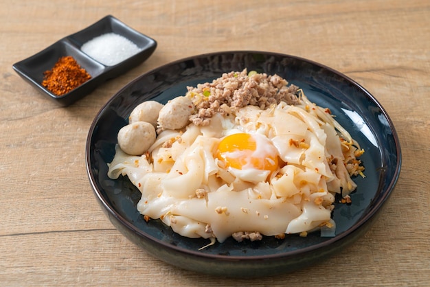 nouilles épicées séchées avec du porc haché, des boulettes de viande et des œufs - style de cuisine asiatique