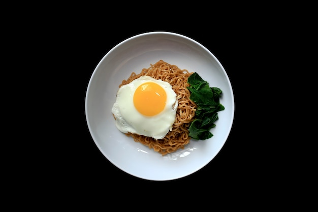 Nouilles frites savoureuses avec œuf et légumes. servi sur assiette blanche