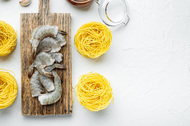 Nouilles avec des ingrédients de fruits de mer, sur une surface en pierre blanche