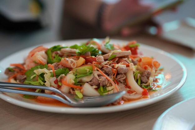 Photo nouilles instantanées saveur salade épicée avec porc haché et légumes frais